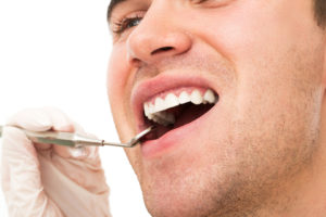 Dentistry. Young guy and his teeth after a tooth extraction