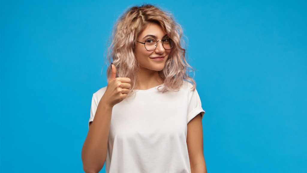 Young girl smiling with a thumbs up because she found a great root canal dentist at Dental Group of Beverly Hills.