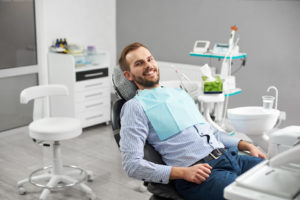 Portrait of happy patient in dental chair. Modern dentistry with the use of new technologies