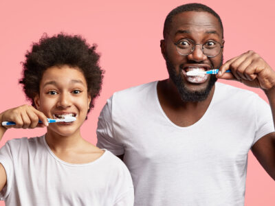 Image of father and son brushing teeth after asking "Do I need a new toothbrush?"